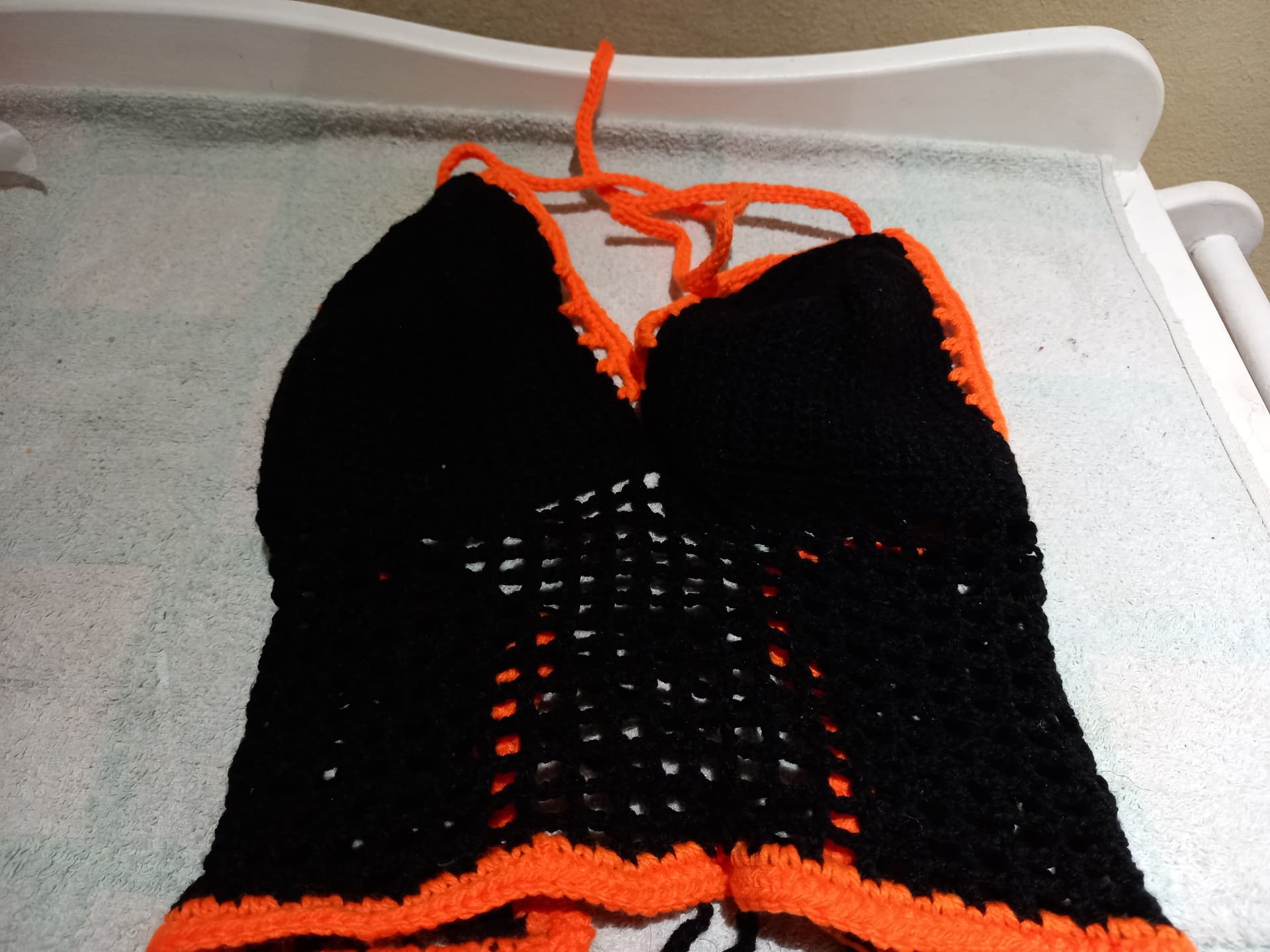 Black crochet bikini top with orange trim
