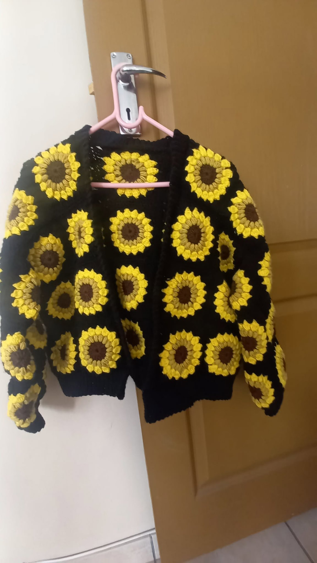 Black crochet cardigan covered in yellow sunflower granny squares